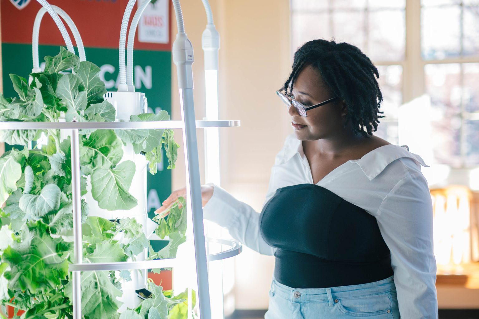 A student in the AADS department tending to a vertical garden.